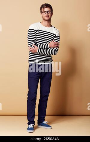 HES un type de style. Portrait en studio complet d'un jeune homme habillé avec élégance et souriant à l'appareil photo. Banque D'Images