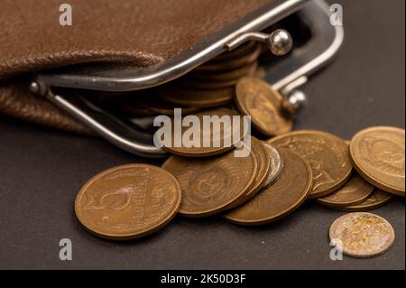 Anciennes pièces de monnaie de l'URSS et portefeuille vintage en cuir marron sur une surface en bois. Gros plan, mise au point sélective. Banque D'Images