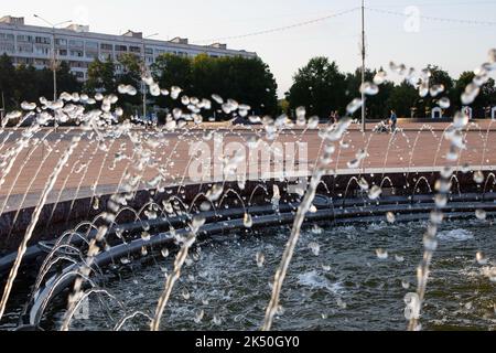 Des éclaboussures d'eau dans la fontaine au coucher du soleil rapprochent Banque D'Images