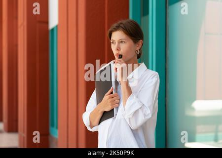 Femme d'affaires fumant une cigarette électronique. Caucasien frustrée femme d'affaires pensive debout rue perdu son emploi a des problèmes financiers fumer la cigarette électronique. Prise de vue portrait en gros plan Banque D'Images