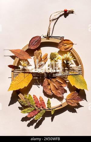 Couronne de porte à fabriquer soi-même à partir de feuilles et de fleurs colorées d'automne. Décoration automnale. Banque D'Images