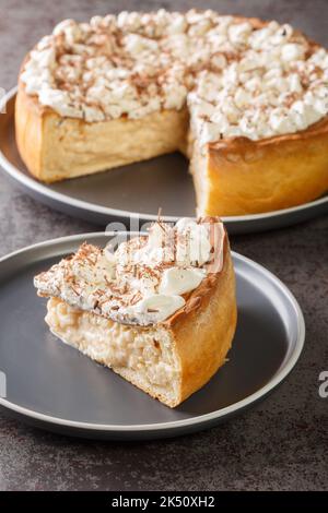 Tarte sucrée avec garniture à base de pudding de riz, garnie de crème fouettée et de copeaux de chocolat, dans une assiette sur la table. Verticale Banque D'Images