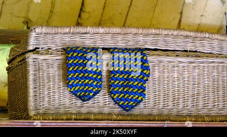 Moufles tricotées bleu laine dans une boîte en osier. Letton fait main. Banque D'Images