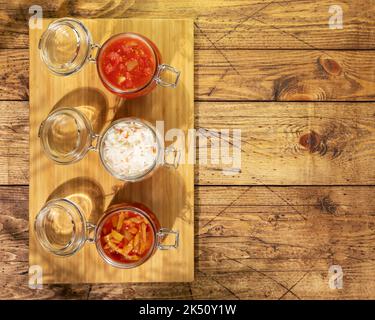 Lecho, choucroute, ajvar en pots de verre sur fond de bois avec espace de copie Banque D'Images