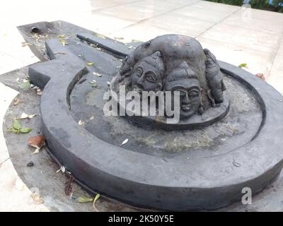 Un Shiva linga fait avec une pierre noire sur une surface plane avec un environnement fait de tuiles Banque D'Images