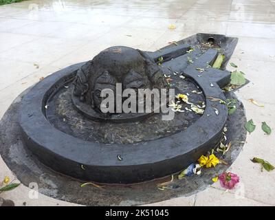 Un Shiva linga fait avec une pierre noire sur une surface plane avec un environnement fait de tuiles Banque D'Images