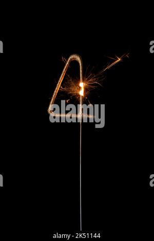 Feu de sparkler doré en forme de numéro quatre, chiffre 4, isolé sur fond noir Banque D'Images