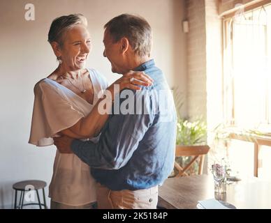 Danse, liberté et retraite avec couple senior dansant en fête, s'amusant et se liant dans le salon. Des aînés amusants, romantiques et actifs Banque D'Images