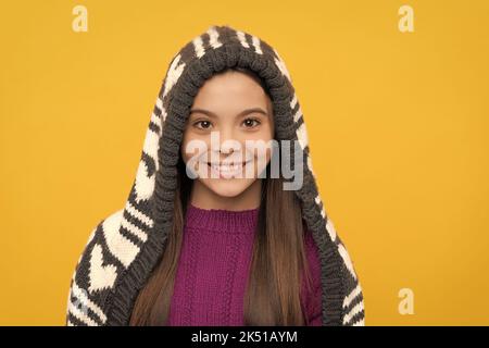 joyeux enfant dans un chapeau à rabat sur fond jaune, hiver Banque D'Images