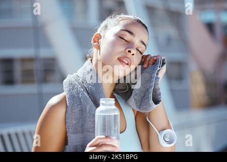 Bouteille d'eau, sueur et femme de course fatiguée en ville urbaine pour des résultats d'entraînement en plein air ou un défi d'exercice en été. Jeune athlète fille et Banque D'Images