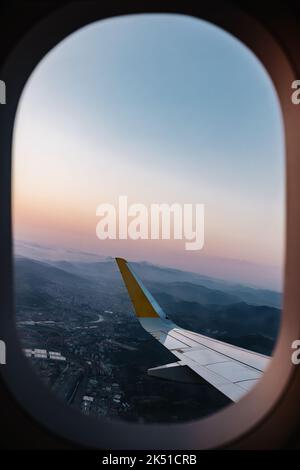 Vue à couper le souffle sur la ville et ciel nuageux derrière la fenêtre de l'avion pendant le vol Banque D'Images