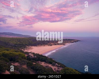 Vue de drone pittoresque paysage de mer calme avec littoral vert et montagnes sous ciel rose nuageux ar coucher de soleil Banque D'Images