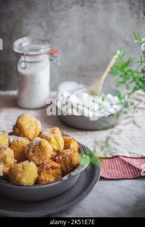 Bol avec des petites bouchées de nuns croquantes et fromage à la crème placé sur la table dans la cuisine à la maison Banque D'Images