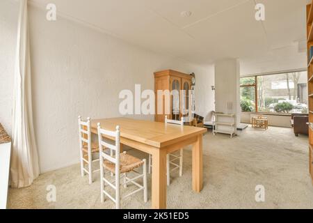 Intérieur de la salle à manger confortable avec table en bois et chaises anciennes dans le cottage conçu dans un style rustique Banque D'Images