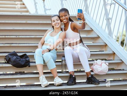 Fitness, téléphone et amis prennent selfie après la course, l'exercice et l'entraînement pour les médias sociaux à l'extérieur sur des marches ou des escaliers. Diversité, bien-être et heureux Banque D'Images