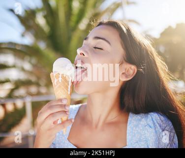 Crème glacée cône manger, femme et dessert d'été à déguster en vacances, vacances et week-end de détente au Portugal. Bonne jeune fille léchant fondre Banque D'Images