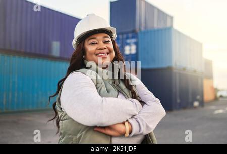 Femme noire, souriez et travaillez dans la logistique avec la pile de conteneurs au chantier naval. Femme, heureux et confiant a la motivation de travail dans l'expédition, le fret et Banque D'Images