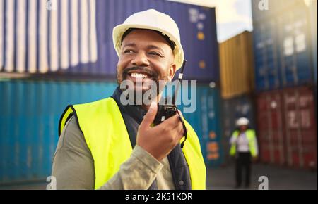 Homme dans la logistique parlant à la radio, la communication dans l'industrie du transport et de l'expédition avec un sourire. Organisation du fret commercial, commerce électronique Banque D'Images