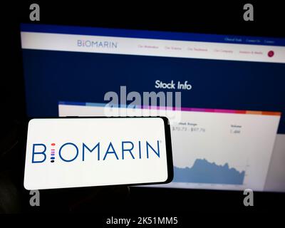 Personne tenant un téléphone portable avec le logo de la société américaine BioMarin Pharmaceutical Inc. À l'écran devant la page Web. Mise au point sur l'affichage du téléphone. Banque D'Images