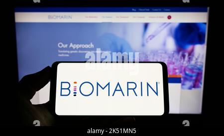 Personne tenant un smartphone avec le logo de la société américaine BioMarin Pharmaceutical Inc. À l'écran devant le site Web. Mise au point sur l'affichage du téléphone. Banque D'Images