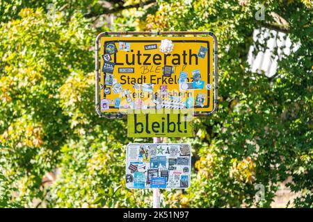 05 octobre 2022, Rhénanie-du-Nord-Westphalie, Erkelenz: Des autocollants et des affiches sont accrochés sur le panneau d'entrée du village de Lützerath, dans le champ de coalfield de Rhenish, qui a été abandonné par ses habitants. Les dernières maisons de Lützerath à la mine à ciel ouvert Garzweiler doivent être démolies pour le lignite en dessous. Le lendemain de la décision des gouvernements fédéral et des États, les militants du mouvement de protection du climat y restent. Photo: Arnulf Stoffel/dpa Banque D'Images