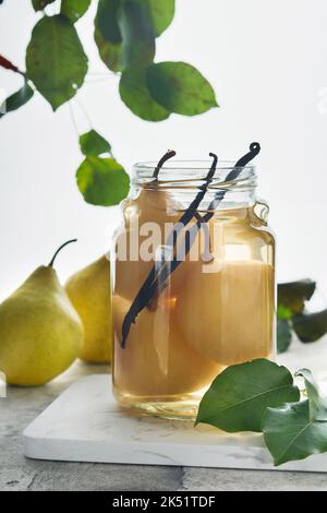 Compote de poire en conserve avec vanilline. Compote de poires. Délicieux compote de poires maison en boîte dans des pots en verre à la maison sur fond clair. Plats faits maison. SP Banque D'Images