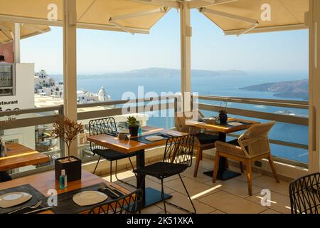 Fira, Santorini - 4 septembre 2022 : vue sur un magnifique restaurant avec une superbe terrasse donnant sur le village pittoresque de Fira et le volcan Banque D'Images