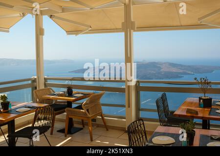 Fira, Santorini - 4 septembre 2022 : vue sur un magnifique restaurant avec une superbe terrasse donnant sur le village pittoresque de Fira et le volcan Banque D'Images