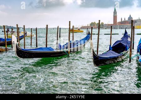 VENISE, ITALIE - OCTOBRE 12 : gondoles amarrées à l'entrée du Grand Canal de Venise sur 12 octobre 2014. Deux personnes non identifiées Banque D'Images