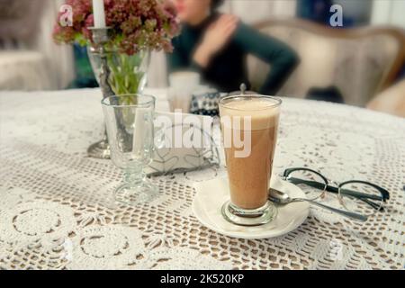 Grand verre avec café au lait Cappuccino sur la table du café. Banque D'Images