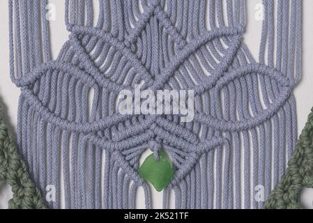 décoration murale en fibre de l'iris et du macramé vert avec symbole fleur de lotus. Technique de nouage à la main de Macrame. Corde de coton bois et verre Banque D'Images