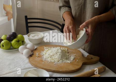 Processus de fabrication de la galette de pomme et de prune maison. Cuisine d'automne traditionnelle de saison. Femme qui fait de la pâte. Concept de cuisson. Banque D'Images