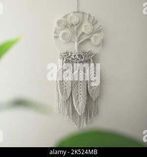 Arbre de vie macrame décoration murale faite à la main avec des feuilles et des plumes blanches avec ficelle de coton et macramé techniques de nœud Banque D'Images