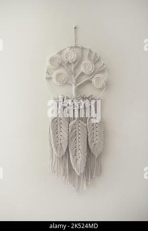 Arbre de vie macrame décoration murale faite à la main avec des feuilles et des plumes blanches avec ficelle de coton et macramé techniques de nœud Banque D'Images