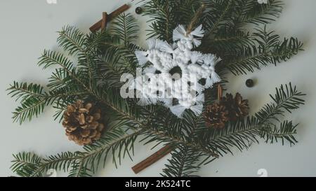 macramé flocon de neige Noël décoration sur branches d'arbre avec macrame fait main de la technique de nouage Banque D'Images