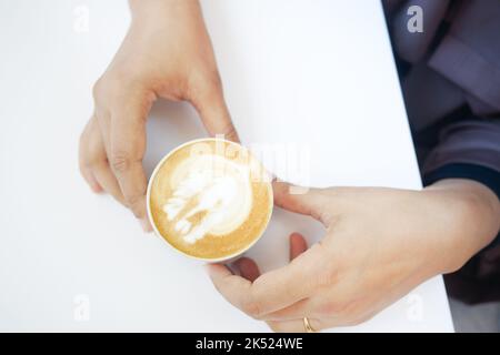 vue de dessus d'une tasse de café tardif avec un motif en forme de coeur sur la table du café Banque D'Images