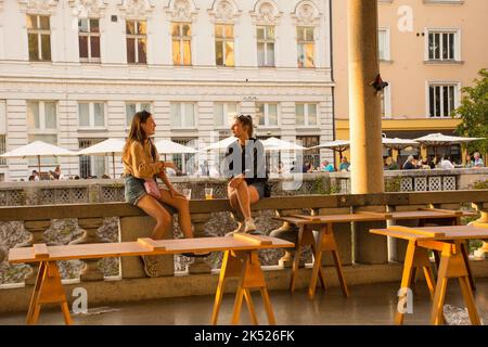 Ljubljana, Slovénie - 3 septembre 2022. Deux jeunes femmes profitent d'une bière ensemble dans un marché extérieur de nourriture de rue à Pogacarjev Trg Banque D'Images