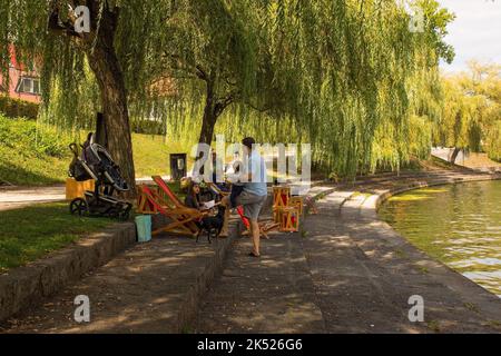 Ljubljana, Slovénie - 4 septembre 2022. Une famille dans une bibliothèque en plein air sur les rives de la rivière Ljubljana, en Slovénie Banque D'Images