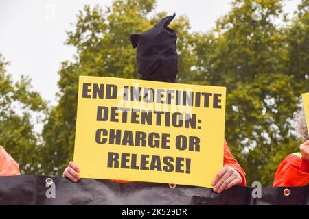 Londres, Royaume-Uni. 5th octobre 2022. Des activistes portant des vêtements orange de « prison » et des capots noirs ont organisé une manifestation sur la place du Parlement demandant la fermeture de la prison tristement célèbre de Guantanamo Bay. Le 8 janvier 2022 a marqué le 20th anniversaire du jour où le premier prisonnier a été emmené dans le centre de détention américain de Cuba. Credit: Vuk Valcic/Alamy Live News Banque D'Images