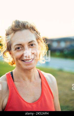 Véritable jeune femme caucasienne mature dans un sport porter dans le parc un après-midi ensoleillé. Banque D'Images