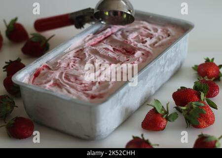 Glace à la fraise maison sortie du congélateur dans un moule à pain. Crème glacée à trois ingrédients faite de fraises fraîches, de crème épaisse ou de crème fouettée Banque D'Images