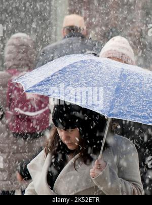 Belgrade, Serbie - 15 décembre 2018 : piétons sous des parasols marchant dans la rue de la ville par une journée enneigée Banque D'Images