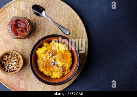 Bouillie de citrouille douce dans un bol en argile avec confiture et noix Banque D'Images