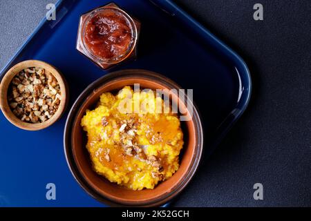 Bouillie de citrouille douce dans un bol en argile avec confiture et noix Banque D'Images