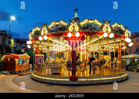 Carrousel illuminé sur la piazza dans la soirée à Alba - petite ville dans la région du Piémont, Italie. Banque D'Images