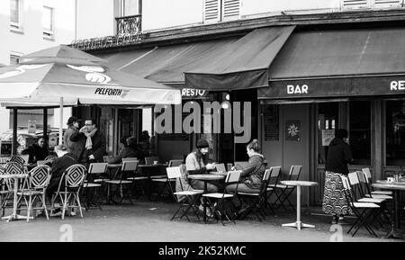 Paris, France - 1 novembre 2021 : les Parisiens et les touristes s'assoient sur la terrasse du café de l'Abibus, rue Bagnolet. Photo historique noir blanc Banque D'Images