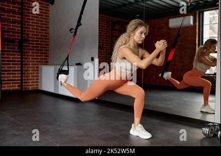 Jeune femme athlétique faisant des exercices avec trx Banque D'Images