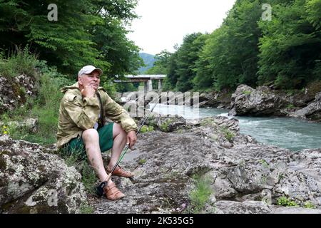 Homme senior sur la rive de la rivière Belaya dans la gorge de granit, Adygea Banque D'Images