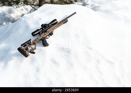 Un fusil de sniper avec une vue optique sur la chasse-neige en hiver Banque D'Images