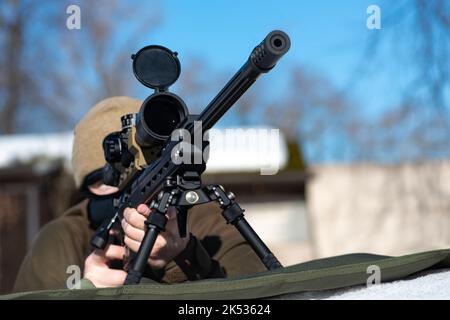 Un fusil de sniper avec une vue optique dans les mains de l'homme visant à poser jour d'hiver ensoleillé Banque D'Images